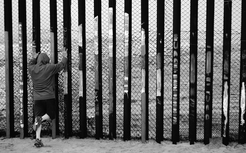 A person looking through a fence in Tijuana, Mexico