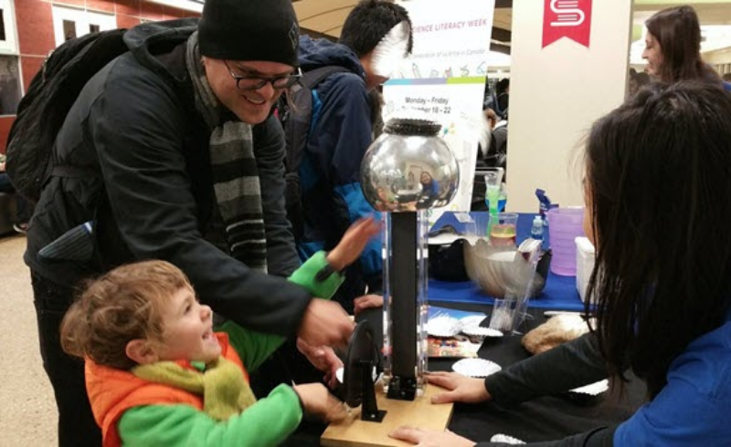 A father and son are excitedly playing with an electric ball.